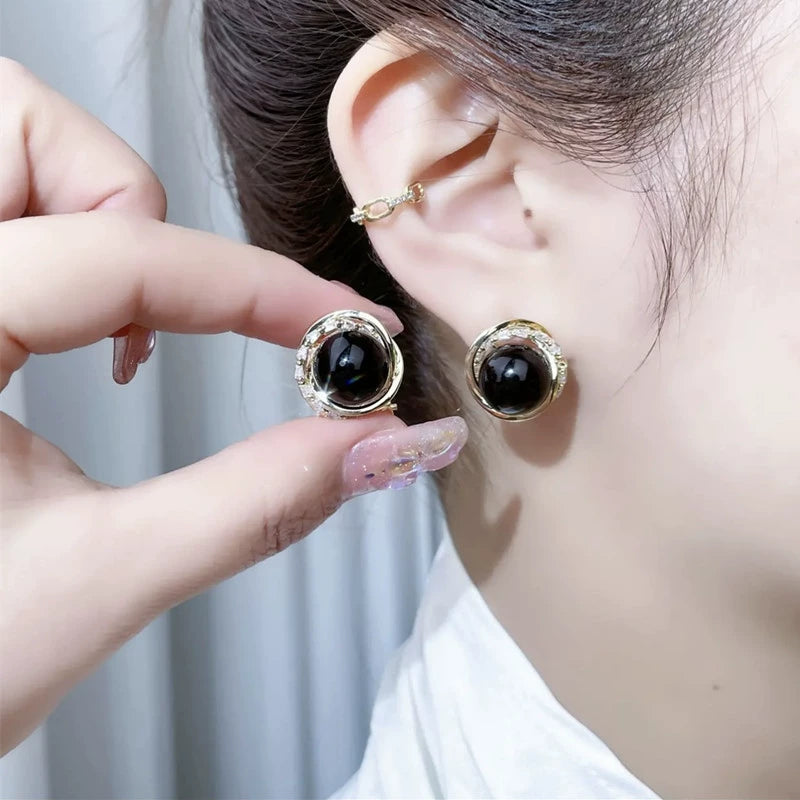 Temperament black pearl earrings ear buckles women's high-end fashion round red bean silver needle earrings retro Hong Kong style earrings